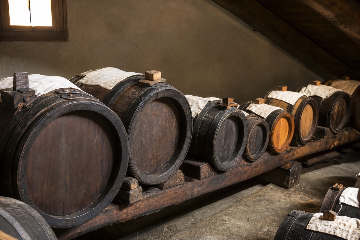 Traditional balsamic vinegar aging in wooden barrels on a Prosciutto di Parma tasting tour